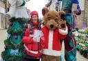 A Huntingdon town ranger with stilt walkers and the BID Bear.