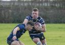 Number eight, Ollie Raine fends off a Bourne RUFC player.