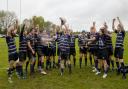 Outgoing first-team captain Tommy Newman lifts the county cup final trophy and celebrates with the rest of the side.