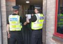 Police officers putting up the closure order notice at the property