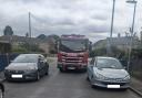 The fire engine nearly got stuck in between two cars.