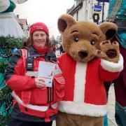 A Huntingdon town ranger with stilt walkers and the BID Bear.