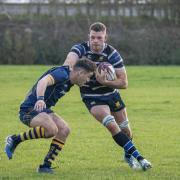 Number eight, Ollie Raine fends off a Bourne RUFC player.