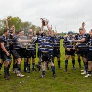 Outgoing first-team captain Tommy Newman lifts the county cup final trophy and celebrates with the rest of the side.