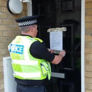 PC Sam Palmer putting up the closure order notice at the property